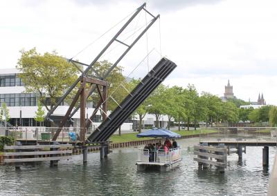 Grillboot fährt auf dem Spoykanal unter der Klappbrücke durch