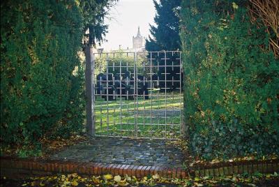 Blick auf den Jüdischen Friedhof durch das Gittertor, im Hintergund die Schwanenburg