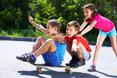 Kinder spielen mit Skateboard auf der Straße 