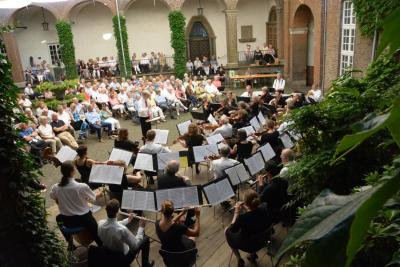Viele Musiker sitzen im Burghof der Schwanenburg