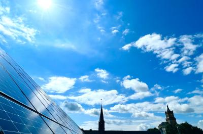 Ein Bild von Solarmodulen auf dem Rathausdach, im Hintergrund die Schwanenburg
