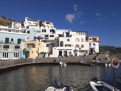 Eine Promenade am Meer mit weißen Häusern und Fischerbooten im Wasser