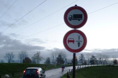Das neue Verkehrszeichen an der Straße "Zum Breijpott" in Kleve. Außerdem ist ein Auto zu sehen, das hinter einem Fahrrad fährt.