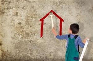 Kind malt Haus auf Betonwand